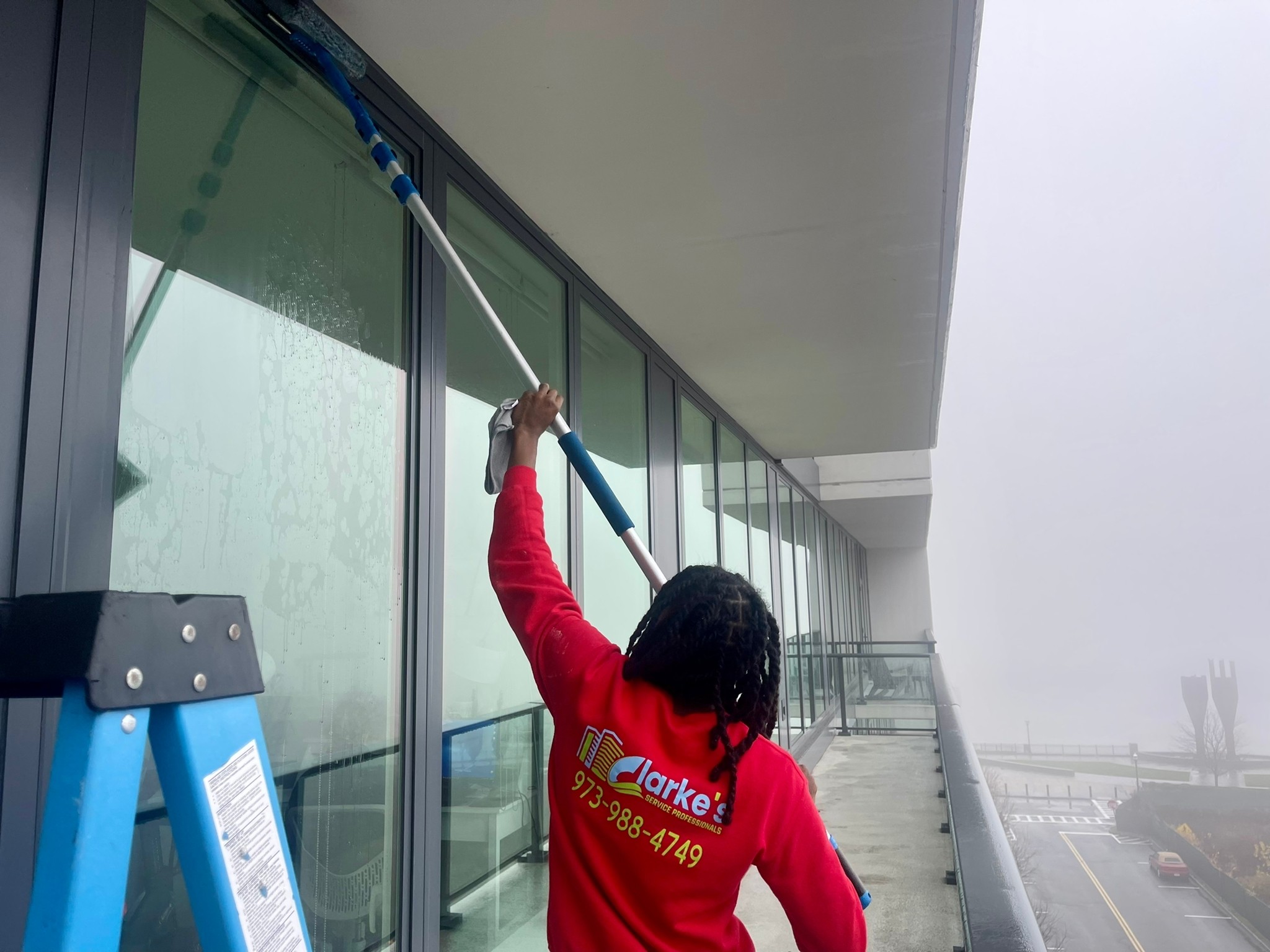 The glass window is being cleaned by Clarke's professional