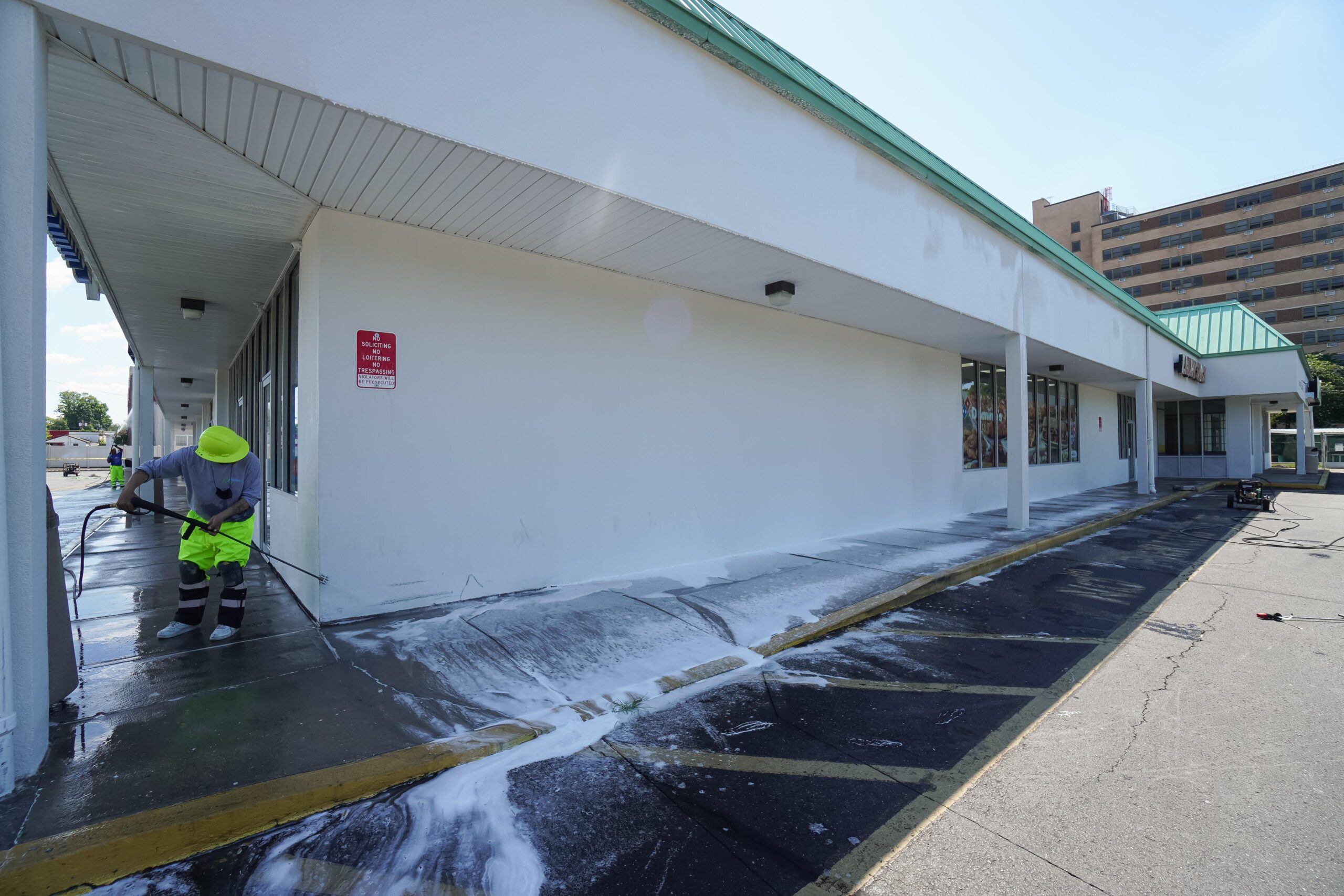 Clarke's professional using a pressure washer on an outer building wall
