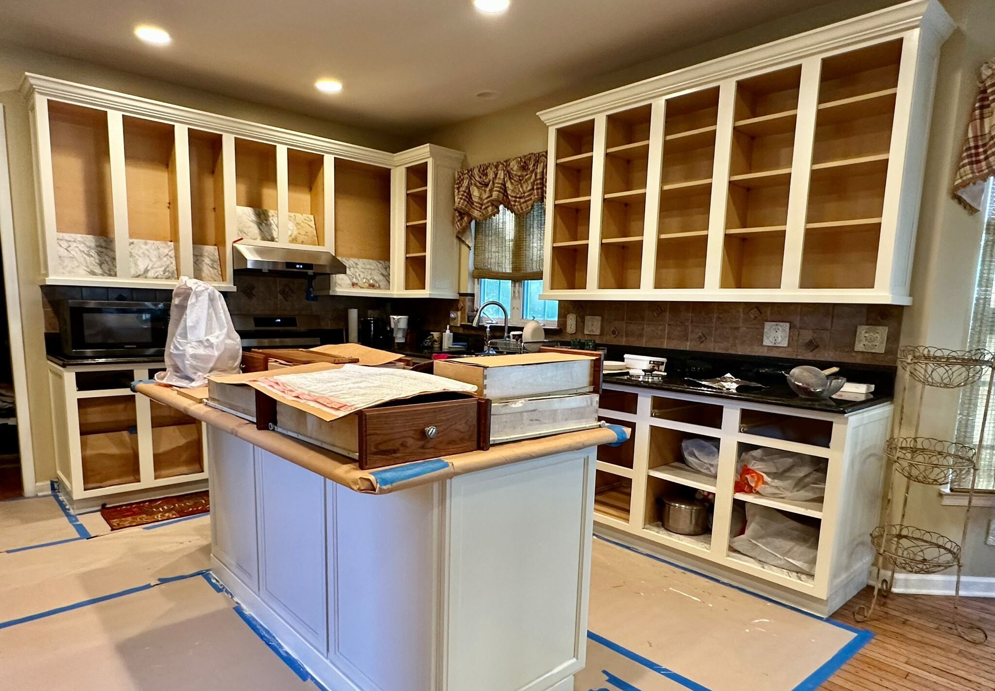 A kitchen with white cabinets under renovation by Clarke's professional.