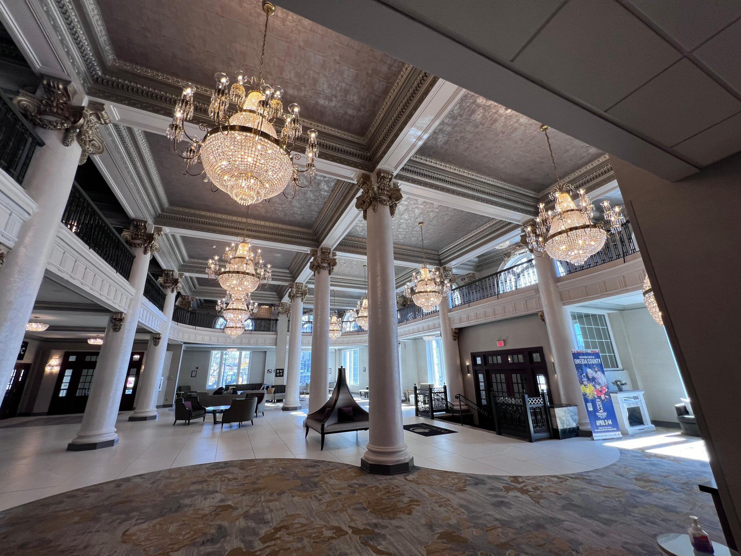 A large room with columns and chandeliers cleaned by Clarkes Service Professionals