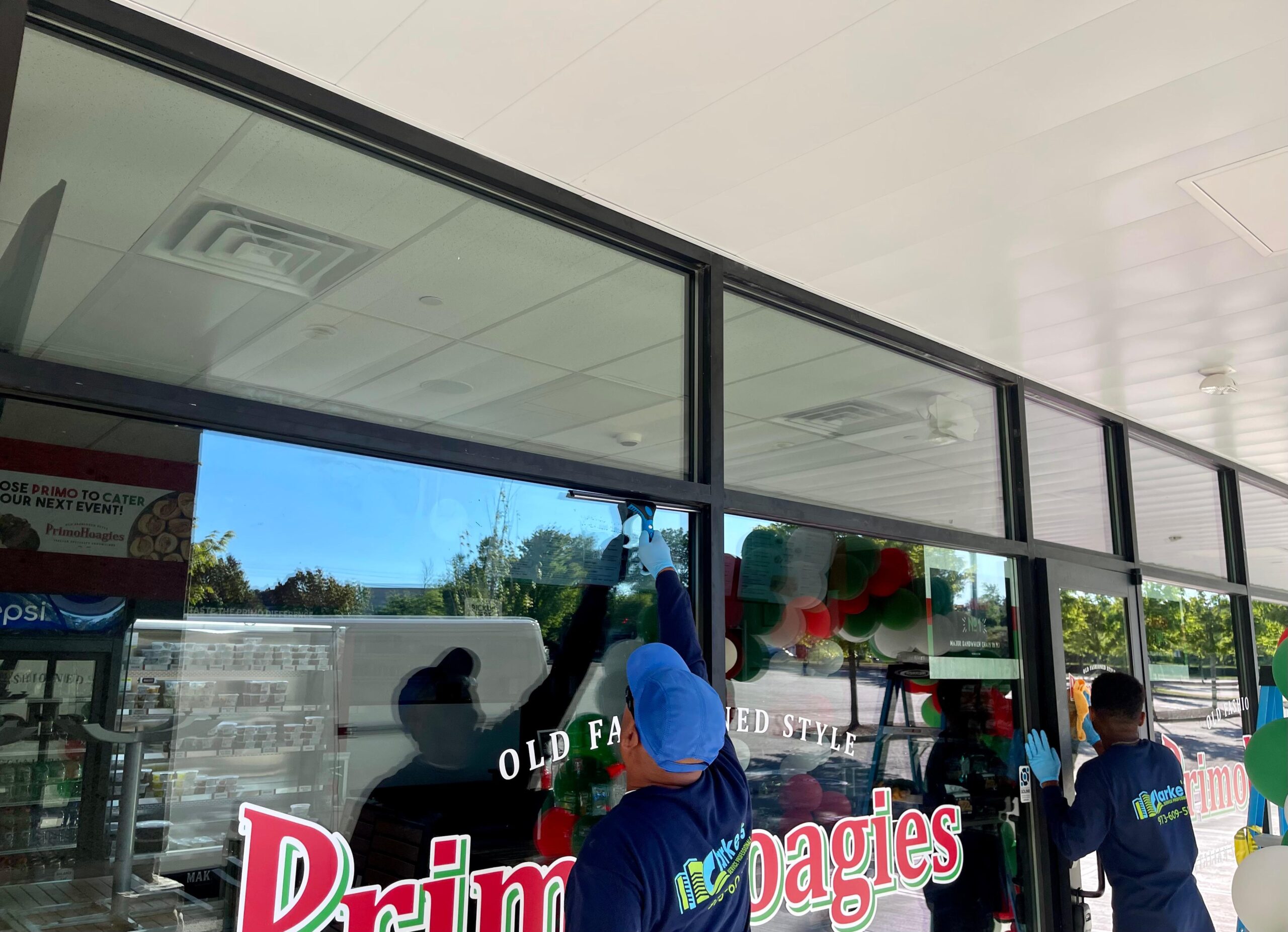 Clarkes professional worker cleaning a mirror window