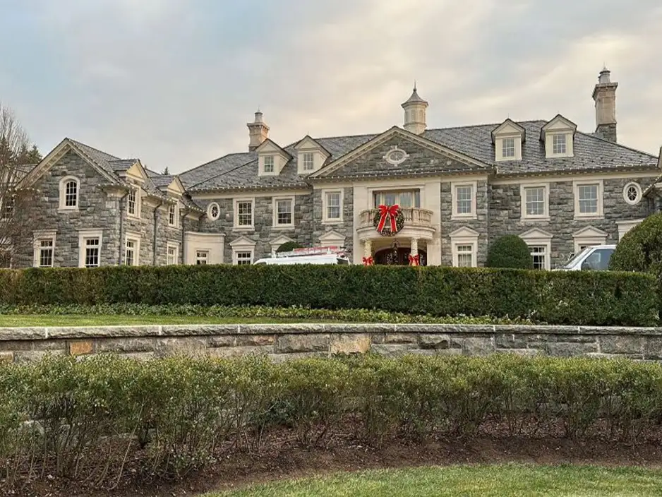 Elegant stone mansion with large windows and a festive wreath on the door