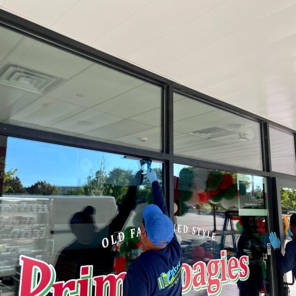 Clarkes professional worker cleaning a mirror window