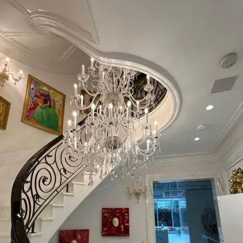 Elegant spiral staircase with a grand crystal chandelier and vibrant artwork